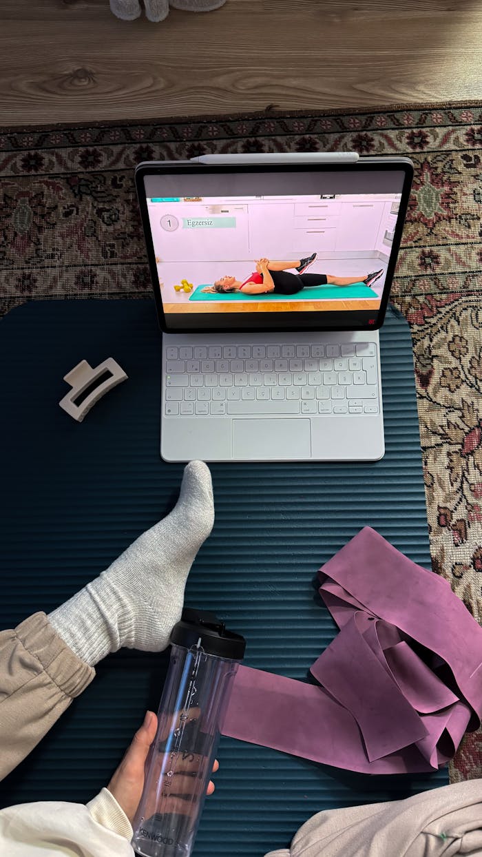 Home A home exercise setup with online fitness class on a laptop. Perfect for remote fitness enthusiasts.